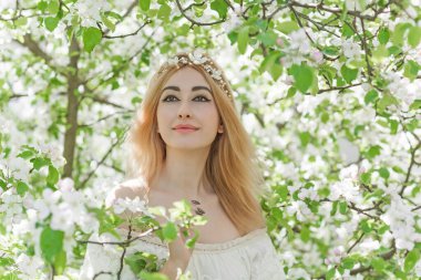 Bahar bahçesinde gelin. Makyajlı ve çiçekli romantik dantelli yarışçı kadın.