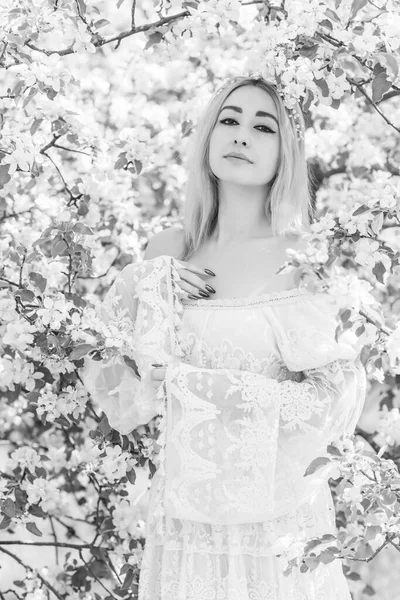 Bahar bahçesinde gelin. Makyajlı ve çiçekli romantik dantelli yarışçı kadın.