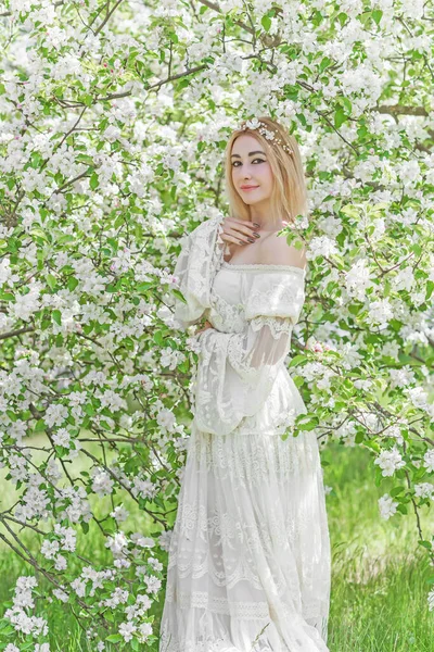 Bahar bahçesinde gelin. Makyajlı ve çiçekli romantik dantelli yarışçı kadın.