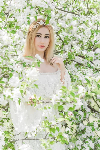 Bahar bahçesinde gelin. Makyajlı ve çiçekli romantik dantelli yarışçı kadın.