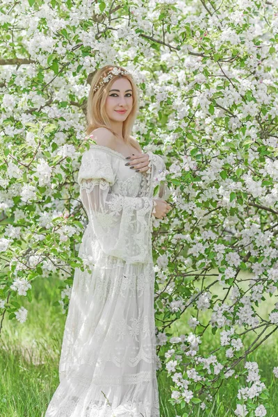 Bahar bahçesinde gelin. Makyajlı ve çiçekli romantik dantelli yarışçı kadın.