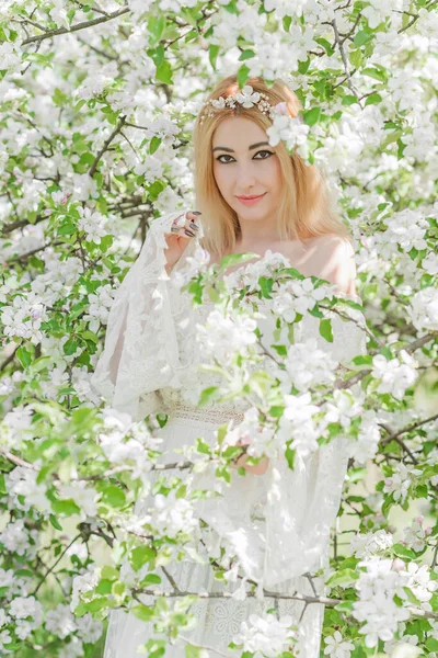 Bahar bahçesinde gelin. Makyajlı ve çiçekli romantik dantelli yarışçı kadın.