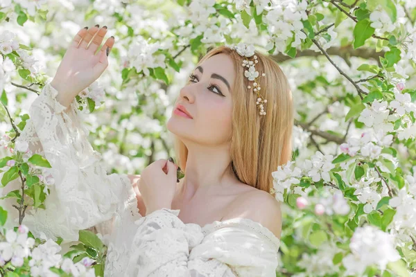 Bahar bahçesinde gelin. Makyajlı ve çiçekli romantik dantelli yarışçı kadın.