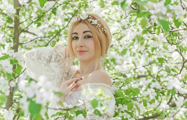 Bahar bahçesinde gelin. Makyajlı ve çiçekli romantik dantelli yarışçı kadın.