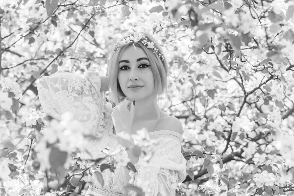 Bahar bahçesinde gelin. Makyajlı ve çiçekli romantik dantelli yarışçı kadın.