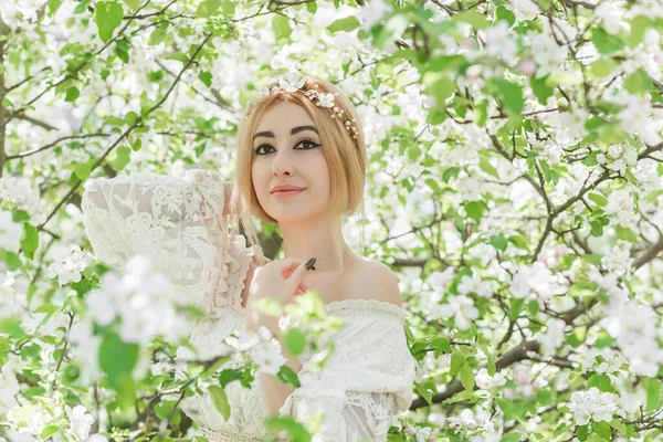 Bahar bahçesinde gelin. Makyajlı ve çiçekli romantik dantelli yarışçı kadın.