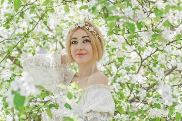 Bahar bahçesinde gelin. Makyajlı ve çiçekli romantik dantelli yarışçı kadın.