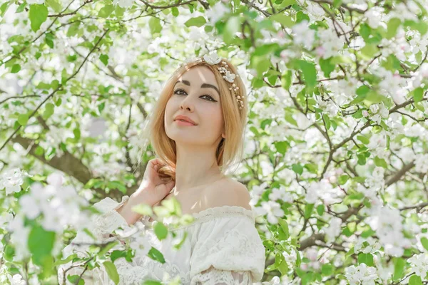 Bahar bahçesinde gelin. Makyajlı ve çiçekli romantik dantelli yarışçı kadın.