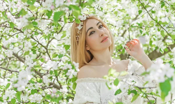 Bahar bahçesinde gelin. Makyajlı ve çiçekli romantik dantelli yarışçı kadın.