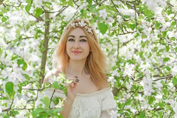 Bahar bahçesinde gelin. Makyajlı ve çiçekli romantik dantelli yarışçı kadın.