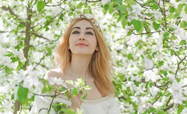 Bahar bahçesinde gelin. Makyajlı ve çiçekli romantik dantelli yarışçı kadın.