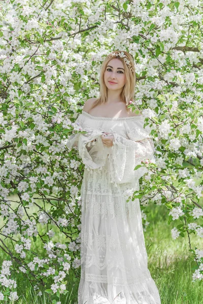 Bahar bahçesinde gelin. Makyajlı ve çiçekli romantik dantelli yarışçı kadın.