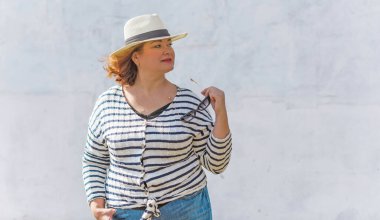 Çekici ve olgun bir kadının portresi, güneşli bir günde şehre doğru yürüyor ve bir şeyler düşünüyor. 40-50 yıl sonra kadın hayatı