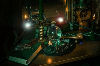 Sihirli şeyler... mum ışığı, kristal top, sihirli değnek, büyü kitabı karanlık arka plan, Slytherin okulu, yeşil estetik, Cadılar Bayramı zamanı