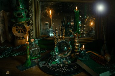 Sihirli şeyler... mum ışığı, kristal top, sihirli değnek, büyü kitabı karanlık arka plan, Slytherin okulu, yeşil estetik, Cadılar Bayramı zamanı