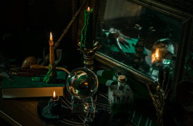 Sihirli şeyler... mum ışığı, kristal top, sihirli değnek, büyü kitabı karanlık arka plan, Slytherin okulu, yeşil estetik, Cadılar Bayramı zamanı