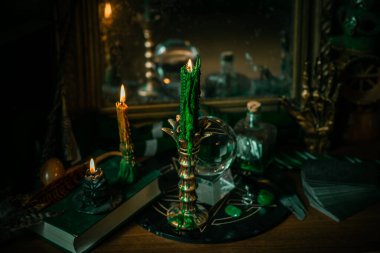 Sihirli şeyler... mum ışığı, kristal top, sihirli değnek, büyü kitabı karanlık arka plan, Slytherin okulu, yeşil estetik, Cadılar Bayramı zamanı