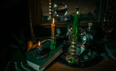 Sihirli şeyler... mum ışığı, kristal top, sihirli değnek, büyü kitabı karanlık arka plan, Slytherin okulu, yeşil estetik, Cadılar Bayramı zamanı