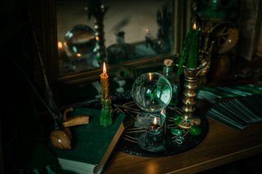 Sihirli şeyler... mum ışığı, kristal top, sihirli değnek, büyü kitabı karanlık arka plan, Slytherin okulu, yeşil estetik, Cadılar Bayramı zamanı
