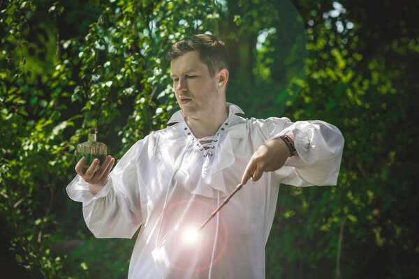 Man wizard with magic wand. Halloween concept, masquerade or cosplay Medieval look