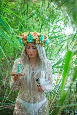 Eski Avrupa büyüsü, Gizemli Pagan sahnesi, gölde mumları olan kadın, ayin. Suda sihirli kehanet