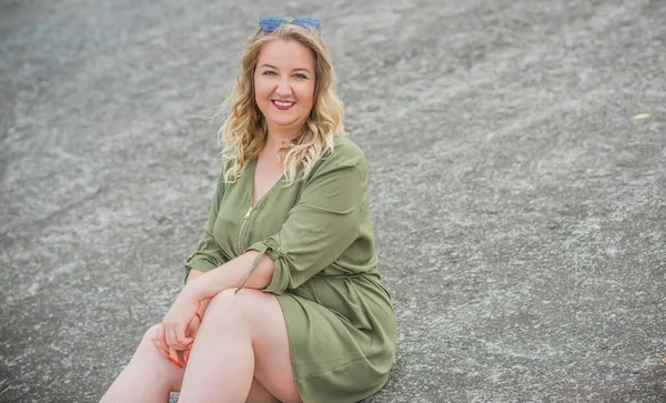 Happy woman of plus size, walks in the city enjoying life. Young lady with excess weight, stylishly dressed at the city park .Natural beauty