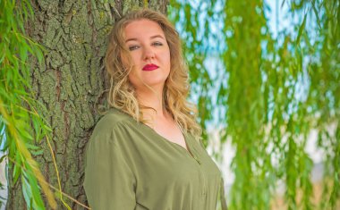 Şehir caddesinde güzel bir model, sıradan giysili Avrupalı bir kadın, büyük boy moda. 