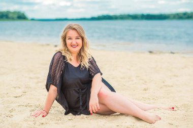 Plajda güzel bir model, sıradan giysili Avrupalı bir kadın, büyük boy moda.