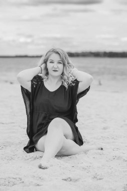 Plajda güzel bir model, sıradan giysili Avrupalı bir kadın, büyük boy moda.