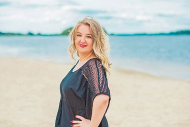 Plajda güzel bir model, sıradan giysili Avrupalı bir kadın, büyük boy moda.