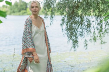 Doğada boho tarzı kıyafetler giyen etnik hippi bir kadın. Açık hava modası. Boho tarzı ve etno kavramı