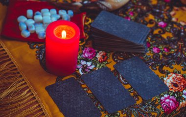 Sihirli sahne, gizemli konsept, falcılık, masadaki tarot kartları.