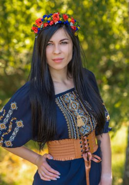 Woman in ethnic dress, flower wreath in hair. Concept of beauty European girl, Boho romantic style