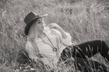 Woman Plus size in American country style black boho jacket, with a fringe, shirt and cowboy hat at nature