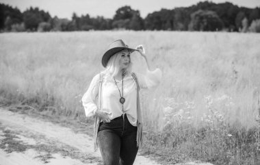 Woman Plus size in American country style black boho jacket, with a fringe, shirt and cowboy hat at nature