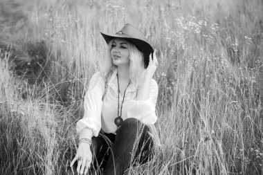 Woman Plus size in American country style black boho jacket, with a fringe, shirt and cowboy hat at nature