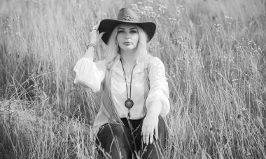Woman Plus size in American country style black boho jacket, with a fringe, shirt and cowboy hat at nature