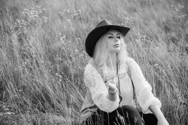 Woman Plus size in American country style black boho jacket, with a fringe, shirt and cowboy hat at nature