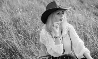 Woman Plus size in American country style black boho jacket, with a fringe, shirt and cowboy hat at nature