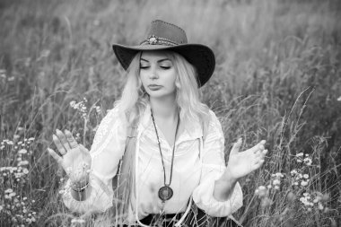 Woman Plus size in American country style black boho jacket, with a fringe, shirt and cowboy hat at nature