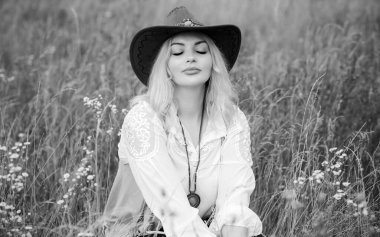 Woman Plus size in American country style black boho jacket, with a fringe, shirt and cowboy hat at nature