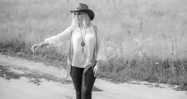 Woman Plus size in American country style black boho jacket, with a fringe, shirt and cowboy hat at nature