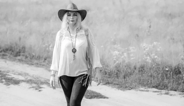 Woman Plus size in American country style black boho jacket, with a fringe, shirt and cowboy hat at nature