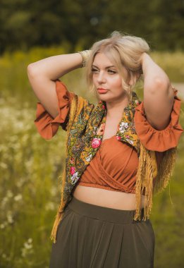Ethnic gypsy woman posing in boho style clothes at nature. Outdoor fashion. Concept of ethnos style 