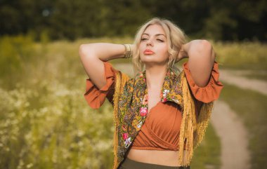 Ethnic gypsy woman posing in boho style clothes at nature. Outdoor fashion. Concept of ethnos style 