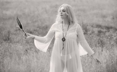 Ethnic hippie woman posing in boho long white lace dress at nature. Concept of ethnos style