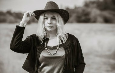 Woman in American country style,  suede leather boho jacket and cowboy hat at nature