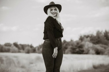 Woman in American country style,  suede leather boho jacket and cowboy hat at nature