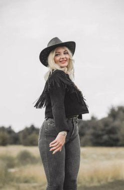Woman in American country style,  suede leather boho jacket and cowboy hat at nature