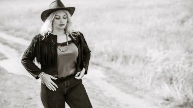 Woman in American country style,  suede leather boho jacket and cowboy hat at nature